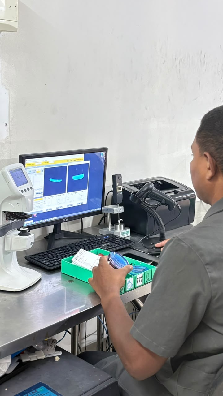 Técnico conferindo uma lente em sistema computadorizado